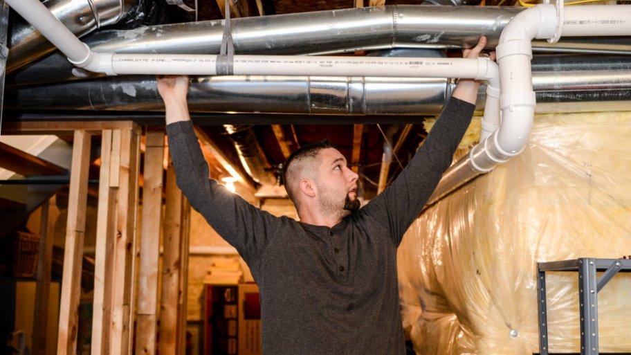 worker installing HVAC venting system